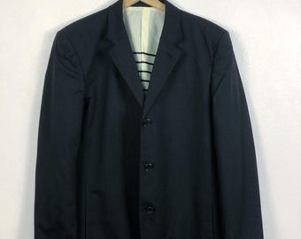 May include: A dark blue blazer with a single-breasted closure and four buttons. The blazer has a notch lapel and long sleeves.