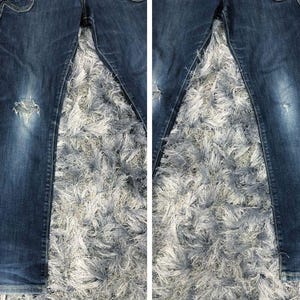 Op de afbeelding: Donkerblauwe spijkerbroek met distressed details, waaronder een gescheurde knie. De jeans heeft een klassiek ontwerp met vijf zakken en een vervaagde wassing. De stof lijkt een mediumgewicht denim te zijn.
