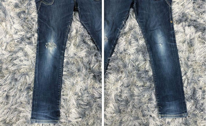 Op de afbeelding: Donkerblauwe spijkerbroek met distressed details, waaronder een gescheurde knie. De jeans heeft een klassiek ontwerp met vijf zakken en een vervaagde wassing. De stof lijkt een mediumgewicht denim te zijn.