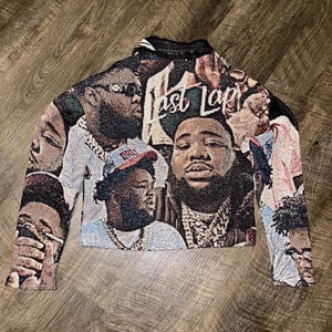 Könnte beinhalten: Eine schwarze und weiße Tapisseriejacke mit einem bunten Muster aus Gesichtern und dem Text "Last Lap".