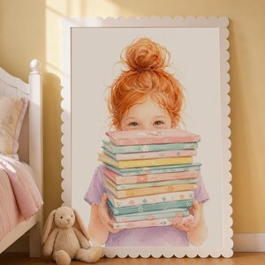 May include: Watercolor print of a young girl with red hair holding a stack of colorful books. The books have floral designs and pastel colors. The print is in a white scalloped frame. A stuffed bunny sits on the floor near the frame.