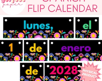 May include: A Spanish flip calendar set featuring black rectangular cards with colorful floral borders. The cards display the text: lunes, el, 1, de, enero, de, 2028. Each card has two white circular holes for hanging. A pink starburst graphic reads PHYSICAL PRODUCT.