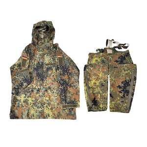 May include: A camouflage jacket with a hood and matching pants. The jacket has a German flag patch on the sleeve. The pants have suspenders and zippers on the sides. The pattern is a mix of green, brown, and black.