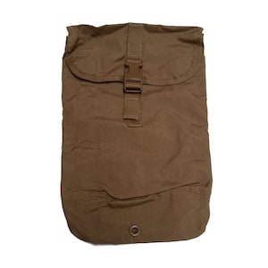 May include: A brown canvas bag with a single buckle closure and a small button on the bottom.