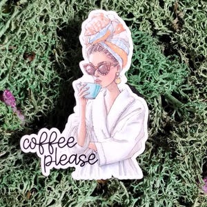 May include: A sticker featuring a woman in a white robe, sunglasses, and a towel on her head, holding a blue cup. The sticker has the text "coffee please" in cursive. The background is green.