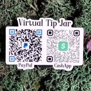 May include: A white sticker with the text "Virtual Tip Jar" and two QR codes for PayPal and CashApp. The sticker is set against a background of green and brown moss.
