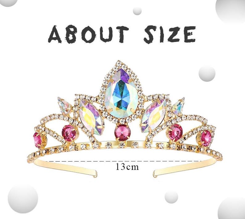 May include: A gold tiara with pink and iridescent gemstones. The tiara is 13 inches wide.