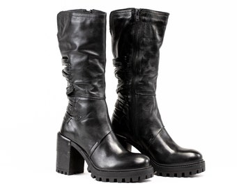 Botas de tacón alto de piel negra hechas a mano, con detalle trenzado.