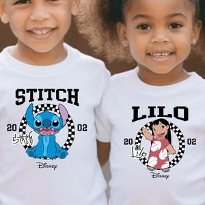 May include: Two children wearing white t-shirts with Disney's Lilo & Stitch characters. One shirt says "STITCH" with a blue Stitch graphic, the other says "LILO" with a Lilo graphic. Both shirts have a black and white checkered circle design.