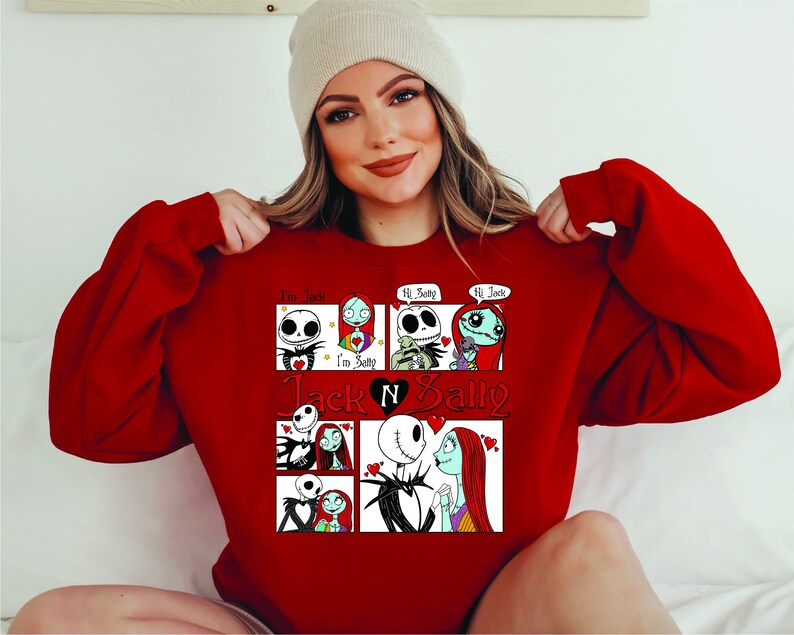 Puede incluir: Una sudadera roja con un gr&aacute;fico de Jack y Sally de The Nightmare Before Christmas. El dise&ntilde;o incluye paneles de estilo c&oacute;mic con los personajes y el texto "I'm Jack", "I'm Sally", "Hi Betty" y "Hi Jack".