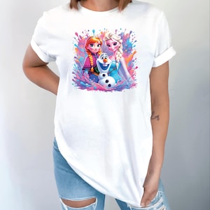 Pu&ograve; includere: T-shirt bianca con una grafica colorata di Anna, Elsa e Olaf del film Frozen. Il design include vivaci spruzzi di rosa, blu e arancione. La maglietta &egrave; realizzata in materiale morbido e ha maniche corte.