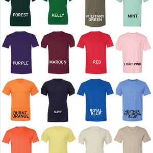 May include: A collection of short-sleeved t-shirts in various colors, including forest green, purple, red, and orange. Each shirt has a different color name printed below it in white text. The shirts are displayed on a white background.