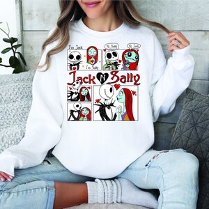 Puede incluir: Sudadera blanca con un dise&ntilde;o de c&oacute;mic de Jack y Sally de The Nightmare Before Christmas. El dise&ntilde;o incluye el texto "I'm Jack", "I'm Sally", "Hi Sally" y "Hi Jack", y las palabras "Jack & Sally" en rojo.