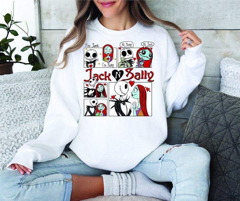 Puede incluir: Sudadera blanca con un dise&ntilde;o de c&oacute;mic de Jack y Sally de The Nightmare Before Christmas. El dise&ntilde;o incluye el texto "I'm Jack", "I'm Sally", "Hi Sally" y "Hi Jack", y las palabras "Jack & Sally" en rojo.