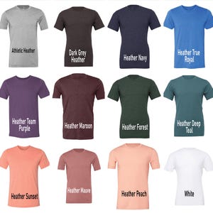 May include: A collection of short-sleeved t-shirts in various colors, including gray, dark grey, navy, blue, purple, maroon, green, teal, orange, mauve, peach, and white. Each shirt has a different color name printed on it.