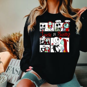 Puede incluir: Sudadera negra con un dise&ntilde;o de Jack y Sally de Pesadilla antes de Navidad. El dise&ntilde;o incluye varios paneles con los personajes y el texto "Jack N Sally" en rojo. La sudadera es de cuello redondo.