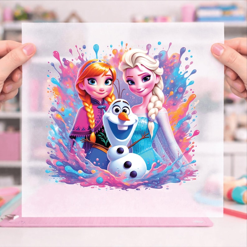 Pu&ograve; includere: Illustrazione colorata con Anna, Elsa e Olaf del film Frozen. Anna ha i capelli rossi intrecciati e indossa un cappotto rosa. Elsa ha i capelli biondi intrecciati e indossa un vestito blu. Olaf &egrave; al centro. Lo sfondo presenta schizzi di vernice.