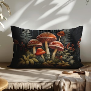 May include: A black and white pillow with a dark forest scene featuring red and white mushrooms with green foliage.