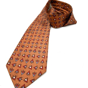 May include: A burnt orange tie with a repeating pattern of red, white, and blue diamond shapes. The tie is made of a smooth fabric and is displayed on a white background.