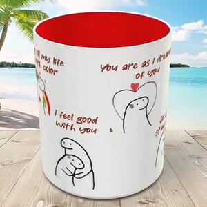 May include: White ceramic mug with a red interior. The mug features black and red illustrations of stick figures with the text "You are as I dream of you", "I feel good with you", and "All my life, your color".