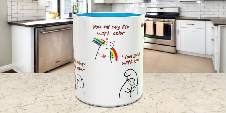 May include: White ceramic mug with a blue rim. The mug features a hand-drawn illustration of a person with a rainbow above their head and the text "You fill my life with color". There is also a hand-drawn illustration of two people hugging with the text "I feel good with you".