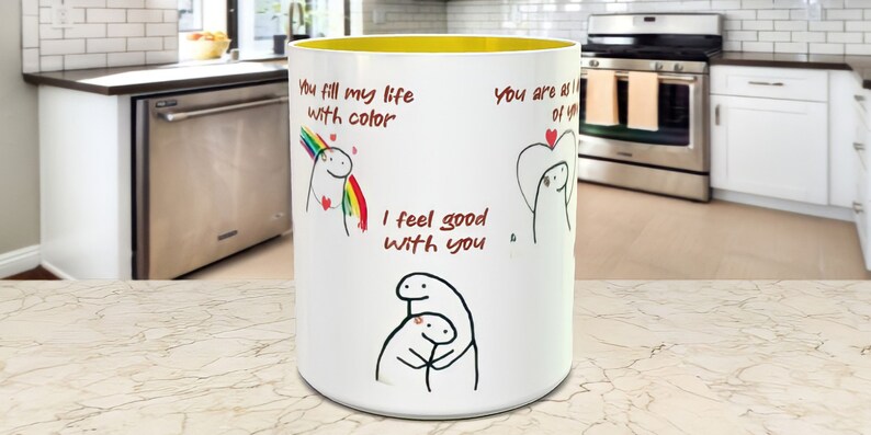 May include: White ceramic mug with a yellow rim. The mug has a cartoon illustration and the text "You fill my life with color", "I feel good with you", and "You are all of you".