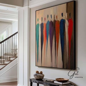 May include: An abstract painting with a black frame, featuring figures in various colors: teal, orange, purple, and red. The artwork hangs above a black bench with decorative items. The room has a staircase and hardwood floors.