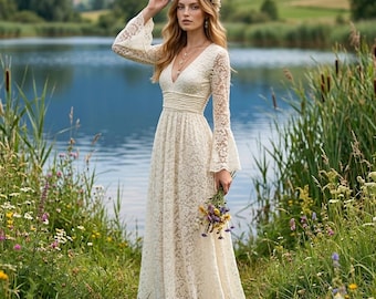 May include: A floor-length cream-colored lace dress featuring long bell sleeves, a deep V-neckline, and a gathered waist. The garment is adorned with an intricate floral pattern throughout the fabric. A floral crown rests on the head.