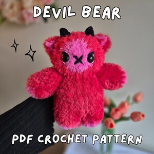 May include: A plush red "Devil Bear" with a pink face and black horns. The bear has a stitched X for a mouth and large black eyes. Text on the image reads "DEVIL BEAR" and "PDF CROCHET PATTERN".