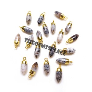 Puede incluir: Una colección de 17 colgantes de piedra de ágata blanca y gris con anillas de salto chapadas en oro. Los colgantes tienen forma de lágrima con una punta puntiaguda.