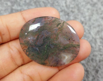 Op de afbeelding: Een groene, roze en witte agaat cabochon met een draaiende patroon. De cabochon is ovaalvormig en heeft een glad, gepolijst oppervlak.