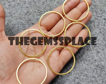 May include: Six gold-colored metal rings of varying sizes. The rings are smooth and have a slightly textured surface.