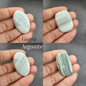 May include: Four green and white striped agate cabochons, each with a different pattern. Green Aragonite.
