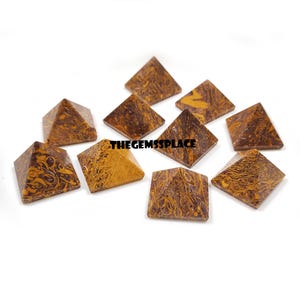 May include: A collection of ten brown and yellow patterned stone pyramids. The pyramids are square-based and have a textured surface. The text "THEGEMSSPLACE" is visible on the image.