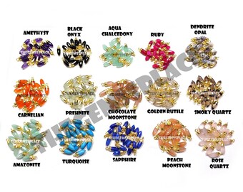 May include: Assortment of 16 different gemstone beads with gold caps. The beads are arranged in rows, with each row labelled with the name of the gemstone. The gemstones include amethyst, black onyx, aqua chalcedony, ruby, dendrite opal, carnelian, prehnite, chocolate moonstone, golden rutile, smoky quartz, amazonite, turquoise, sapphire, peach moonstone, and rose quartz.