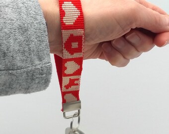 Llavero de cincha artesanal. Diseño en rojo y crema. Llavero de mano. Llavero trenzado resistente. Accesorio para amantes de los perros.