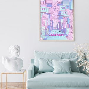 May include: A framed poster with a pink and blue illustration of a Japanese street scene. The poster features the text "JAPAN" and "ようこそ" in Japanese. The poster also features signs with the text "東京" (Tokyo), "大阪" (Osaka), and "日本" (Japan).