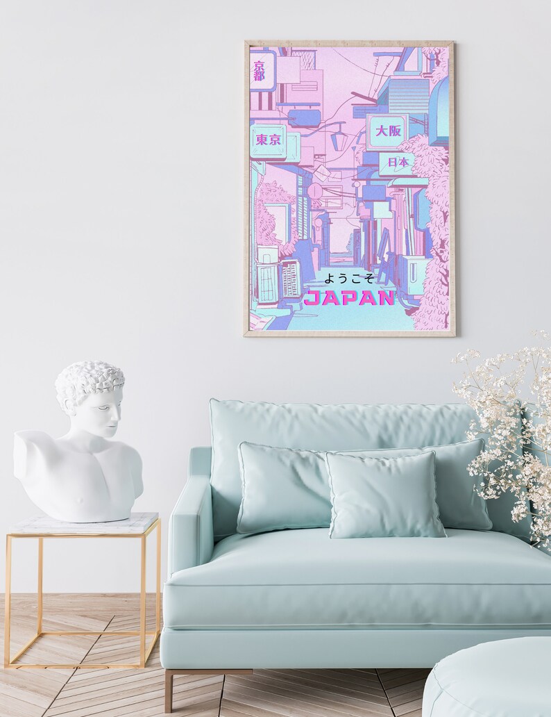May include: A framed poster with a pink and blue illustration of a Japanese street scene. The poster features the text "JAPAN" and "ようこそ" in Japanese. The poster also features signs with the text "東京" (Tokyo), "大阪" (Osaka), and "日本" (Japan).