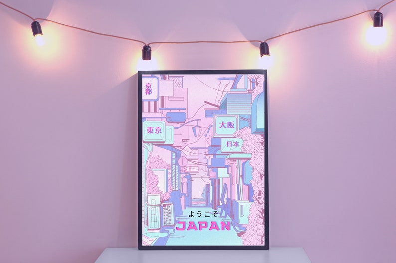 May include: A framed print of a Japanese city street scene with pink and blue buildings and the text "よっこそ JAPAN" in pink and blue lettering.