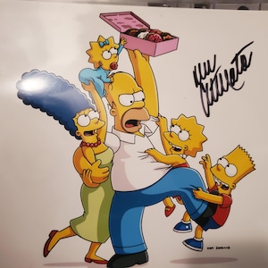 May include: A cartoon print of the Simpson family. Homer holds a box of donuts, surrounded by Marge, Bart, Lisa, and Maggie. The image includes an autograph in black ink.