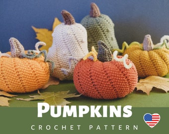 May include: Crochet pattern for making pumpkins. The pattern includes five pumpkins in different colors and sizes, including orange, green, and white. The pumpkins are arranged on a green surface with fall leaves.