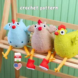 May include: Three crochet pattern chickens in light blue, beige, and lime green. Each chicken features a red comb, white and black eyes, and yellow legs. The beige and lime green chickens wear red boots. The text crochet pattern is visible.