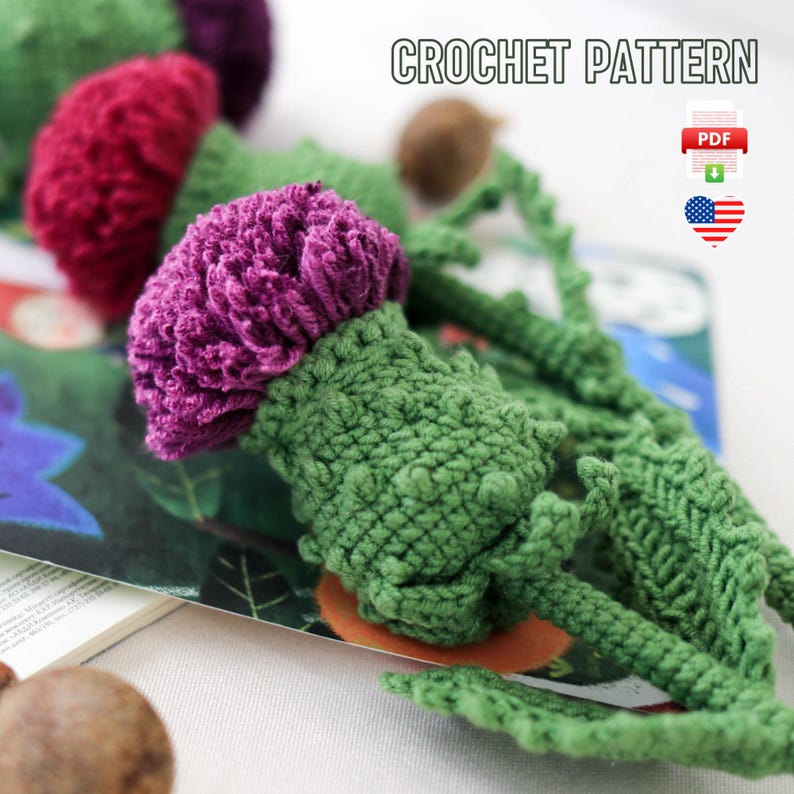 Pode incluir: Padr&atilde;o de croch&ecirc; para uma flor de cardo roxa e verde. O padr&atilde;o est&aacute; dispon&iacute;vel para download em PDF.