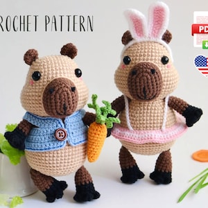 May include: Crochet pattern for two adorable capybara amigurumi toys. One capybara is wearing a blue vest and holding a carrot, while the other is dressed as a bunny with pink tulle skirt. The pattern is available as a PDF download.