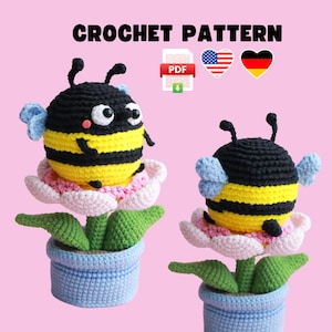 Puede incluir: Patrón de crochet para una abeja en una maceta. La abeja es amarilla y negra con una cabeza negra y una flor blanca. La maceta es azul y blanca.