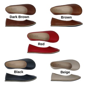 Peut inclure: Collection de ballerines plates de diff&eacute;rentes couleurs : marron fonc&eacute;, marron, rouge, noir et beige. Chaque chaussure a un bout arrondi et une semelle fine. Le nom de la marque "RUBY BAREFOOT" est imprim&eacute; sur la semelle int&eacute;rieure.