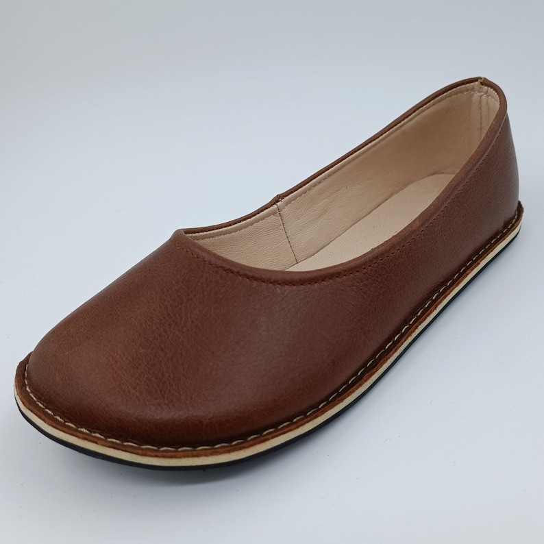 Peut inclure: Une ballerine en cuir marron. La chaussure a un bout arrondi, une semelle cousue et un int&eacute;rieur cr&egrave;me. Le cuir a un aspect textur&eacute;. La chaussure est con&ccedil;ue pour le confort et le port quotidien.