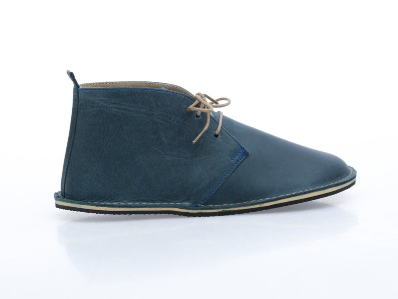 May include: Blue leather ankle boots with a lace-up closure and a cream-coloured sole.