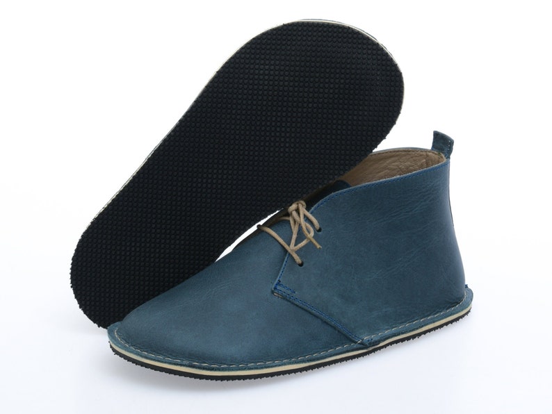 May include: Blue leather ankle boots with a lace-up closure and a rubber sole.