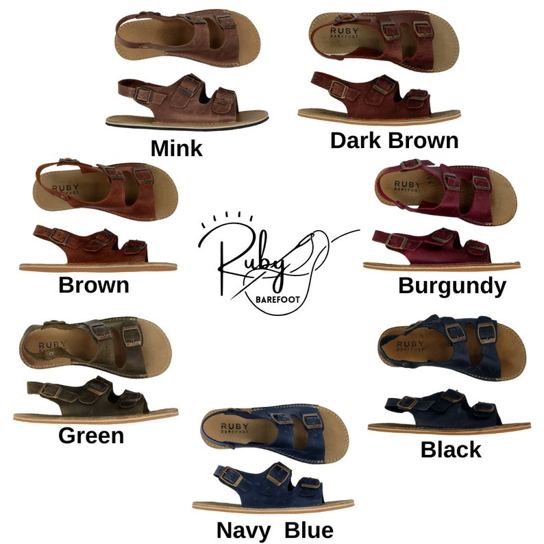 May include: A variety of sandals in different colors, including brown, green, navy blue, black, burgundy, and mink. The sandals have two straps with buckles and a back strap. The sandals are made by Ruby Barefoot.